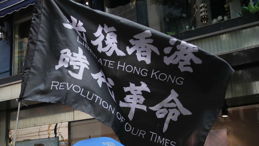 Protesters carry the flag which reads "Liberate Hong Kong, revolution of our time" in Causeway Bay.