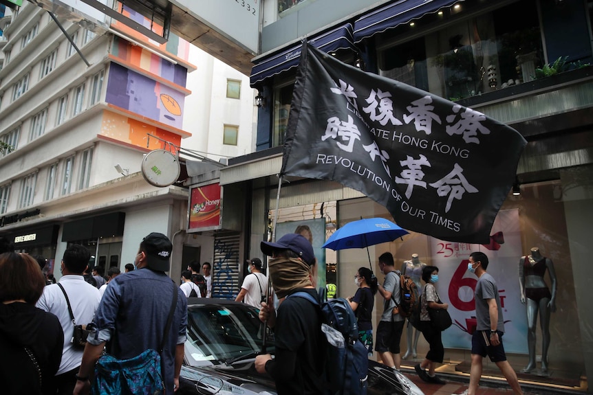 Protesters carry the flag which reads "Liberate Hong Kong, revolution of our time" in a street in the city.