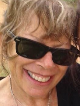 A tight head shot of a smiling Jenni Pratt wearing black sunglasses.