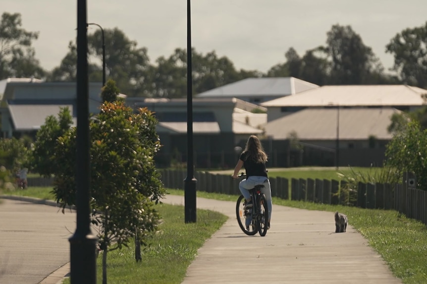 woman rides a bicycle along a path in Moreton Bay 