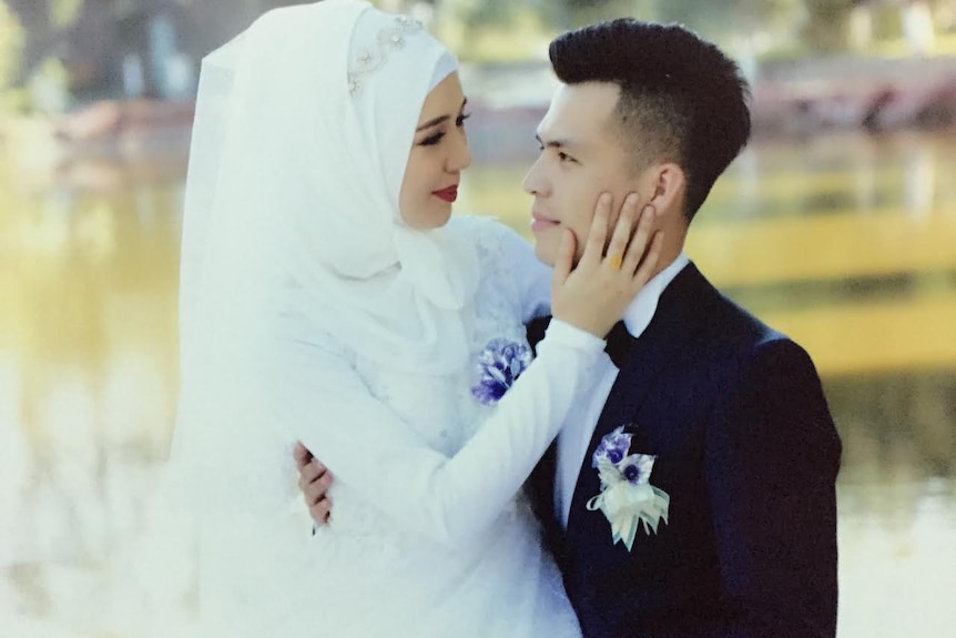 A man and a woman look at each other at a wedding photo shoot.