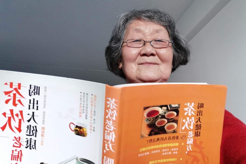 A woman holding a cooking book