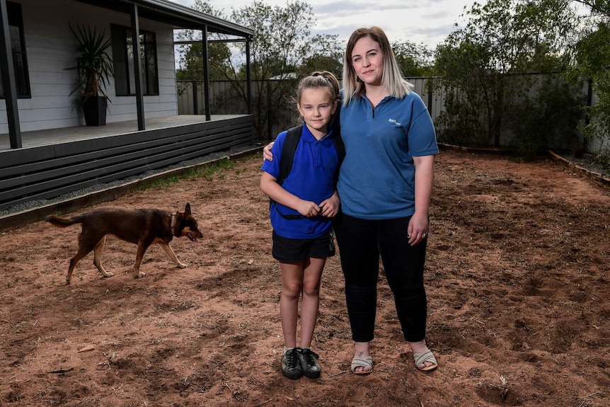 Molly Negfeldt with her daughter, Ella with a dog in the background and dirt.