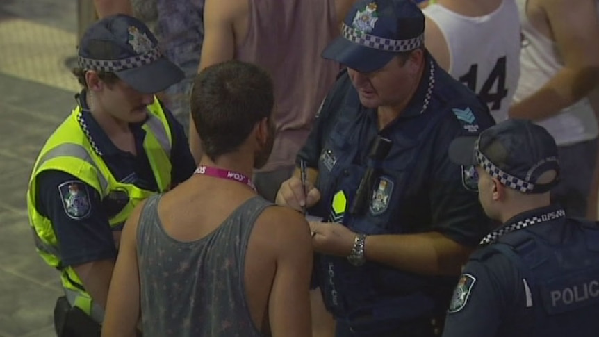 Police talk to a reveller at Gold Coast schoolies festival on November 24, 2014