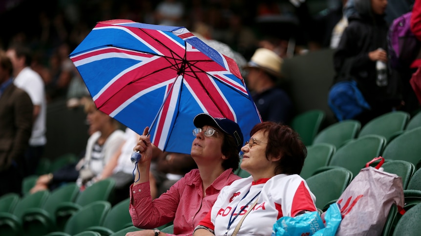 Umbrellas up ... the men's singles at Wimbledon has been delayed due to rain.