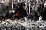 Forensic experts investigate the scene at the community hall where Saudi-led warplanes struck a funeral