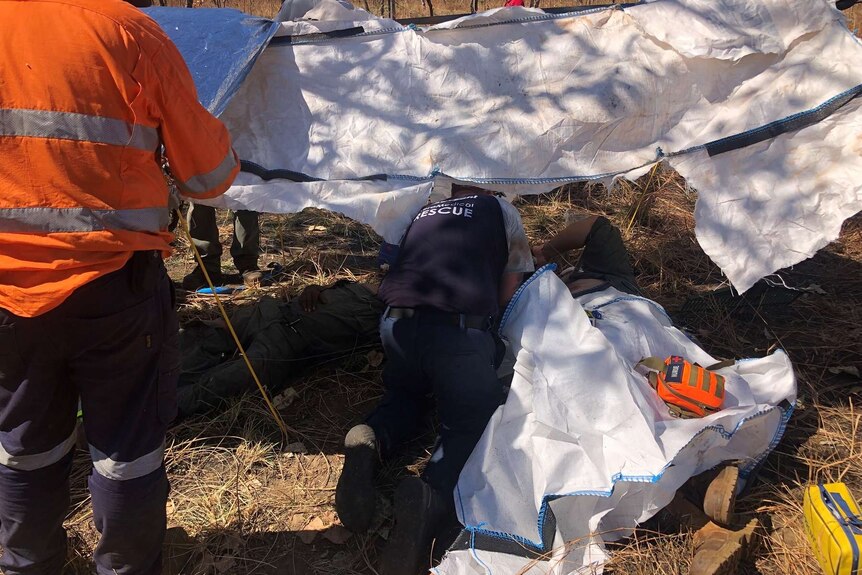 Emergency services treat an injured man at a helicopter crash site in Kakadu.