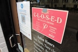 Close up photo of a business sign telling people it's closed
