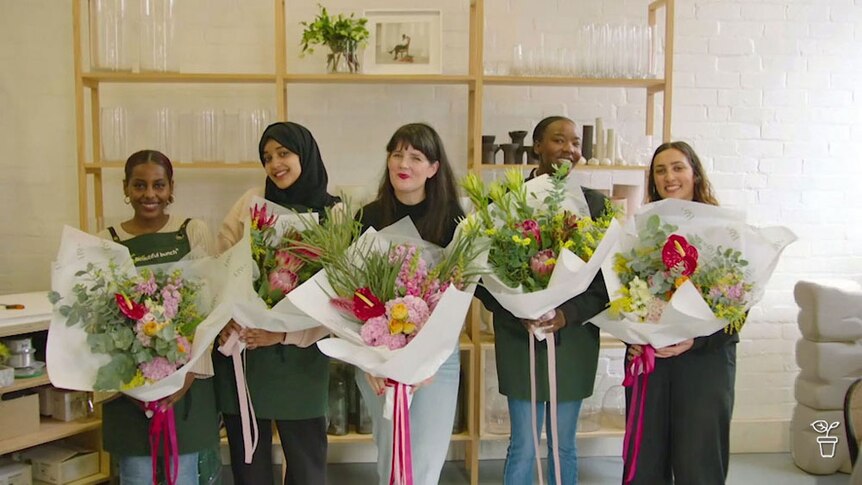 A group of florists holding bunches of flowers.