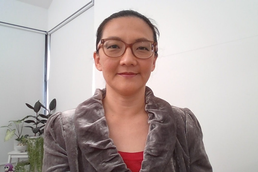 a woman wearing glasses looking at a camera