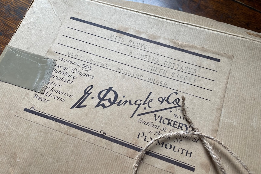 A brown box tied with a string with a fading label from R Dingle and Co from Plymouth addressed to a Miss Bloye. 