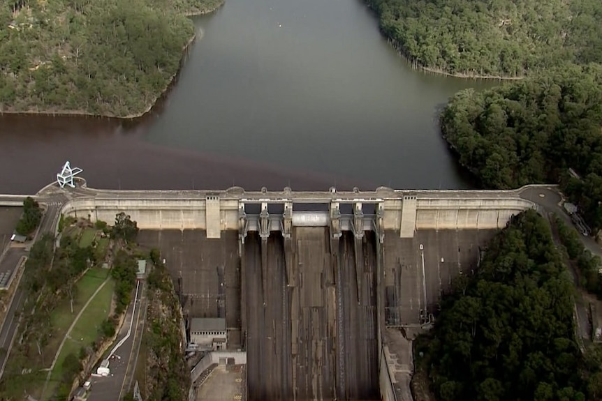 The Warragamba Dam from a helicopter above surrounded by trees