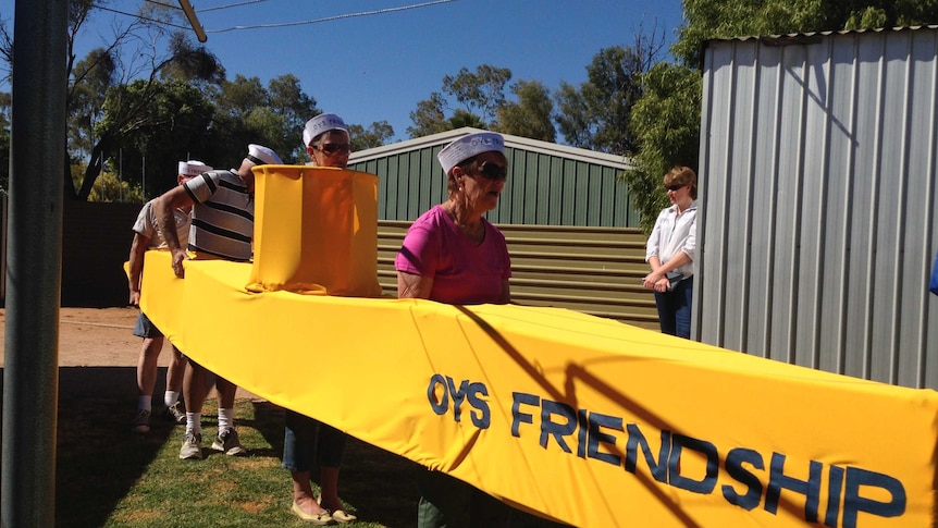 Four competitors in the Henley-on-Todd dry river bed regatta's standing in their yellow submarine.