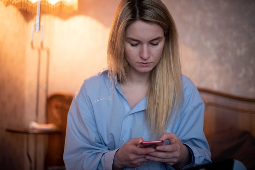 Maria looks at her phone.