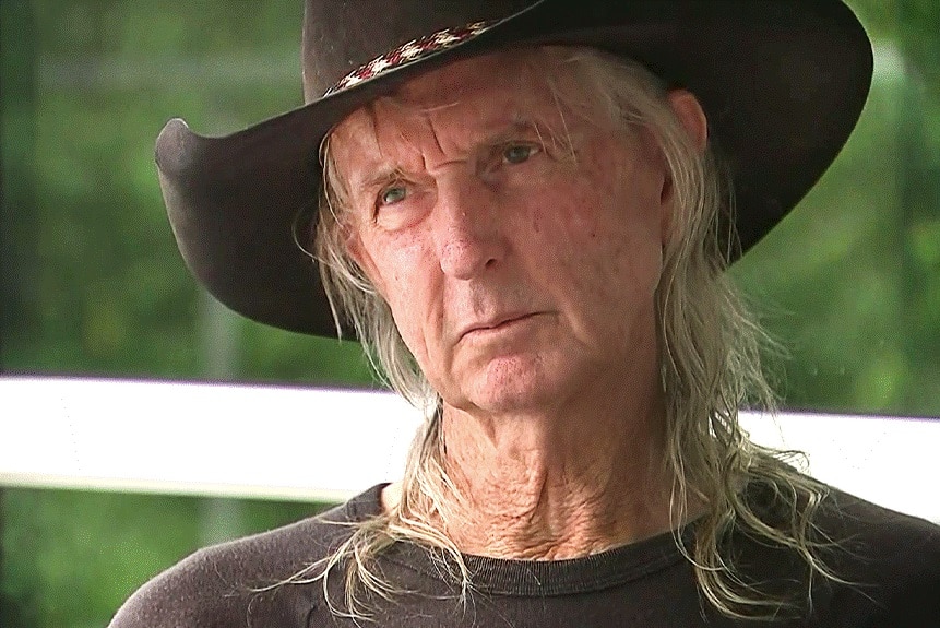Video still of Trevor Lennox with long light-coloured hair and wearing a hat.
