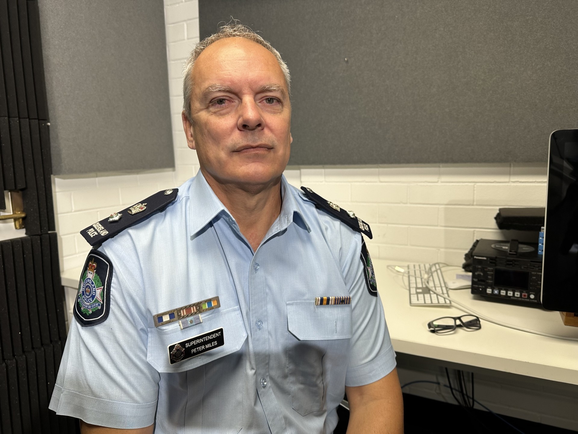 Un policía uniformado de mediana edad está sentado en una oficina.