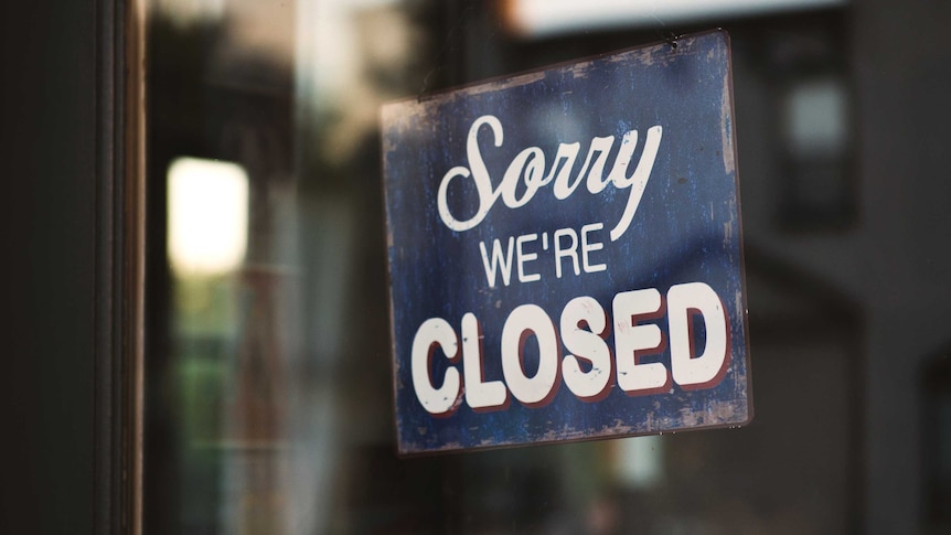 A sign reading "sorry we're closed" hangs in a window.