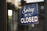 A sign reading "sorry we're closed" hangs in a window.