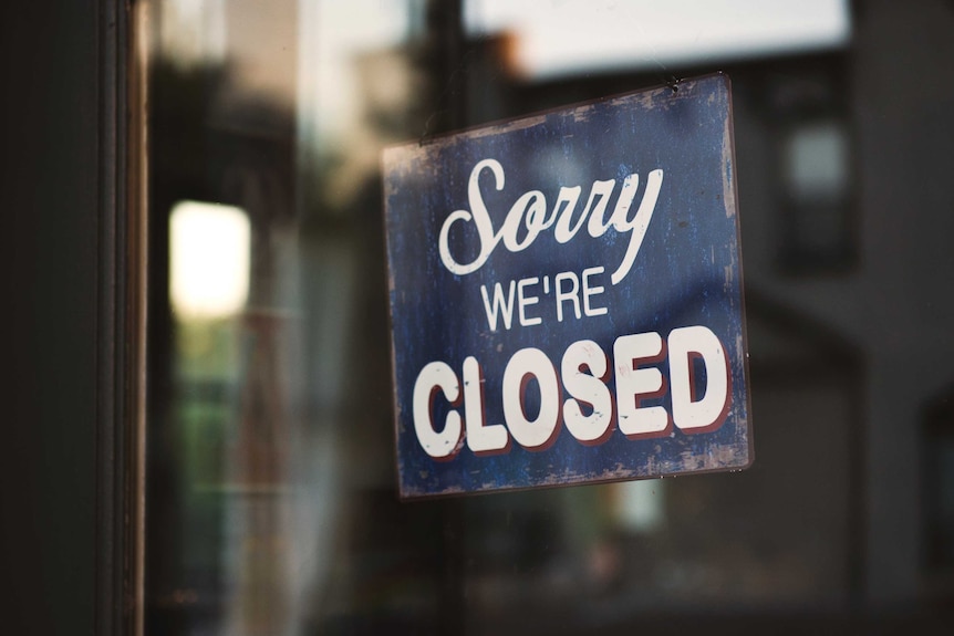 A sign reading "sorry we're closed" hangs in a window.