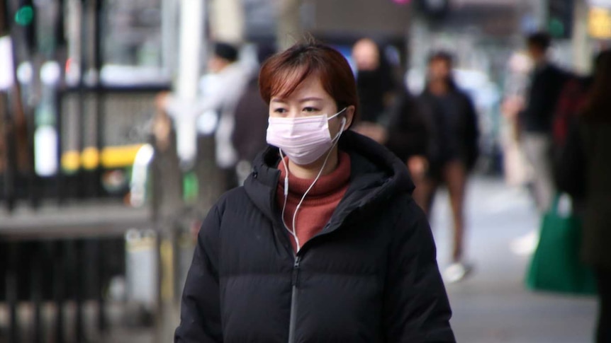 A woman is pictured wearing a face mask on a Melbourne street.