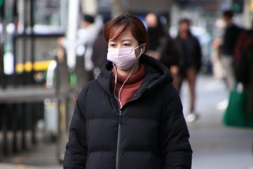 A woman is pictured wearing a face mask on a Melbourne street.