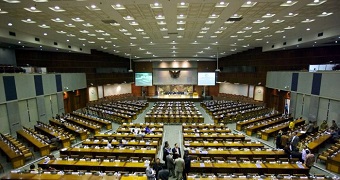 The inside of the Indonesian House of Representatives, showing a rows of seats facing a small stage
