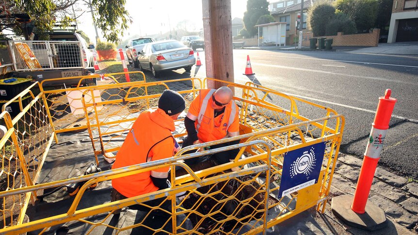 Technicians lay NBN cable in a Melbourne Street.