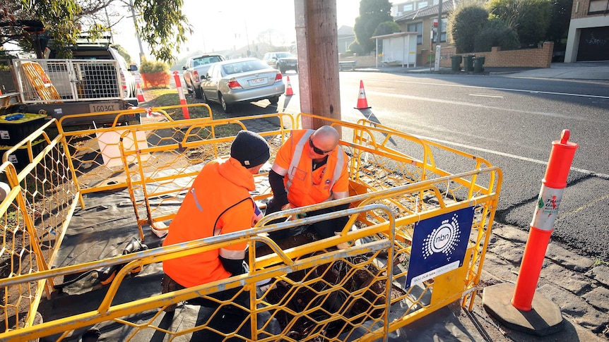 Technicians lay NBN cable in a Melbourne Street.