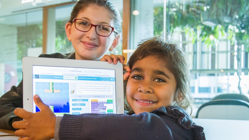 Eva Hopewell and Kobie Smith hold an iPad with their version of Flappy Bird.