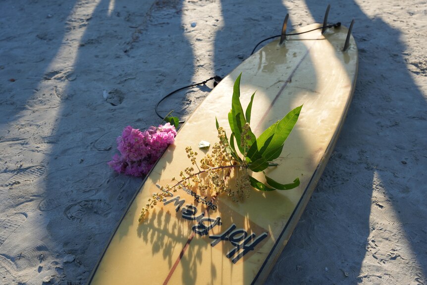 Floral tributes laid on a surfboard 