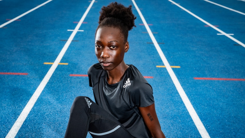 Bendere Oboya sits on an athletics track.