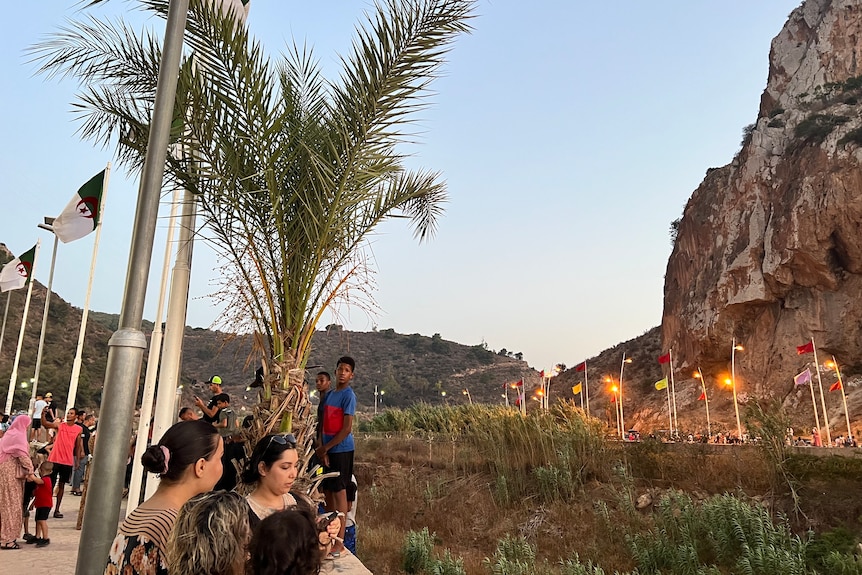 La gente se para en la brecha fronteriza entre Marruecos y Argelia.