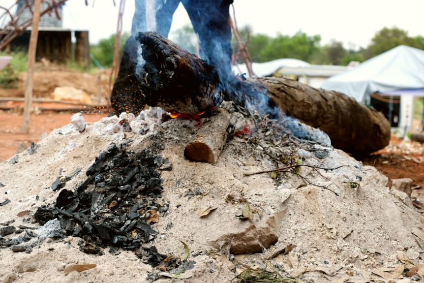 s small fire in an outdoor area surrounded by lots of ash