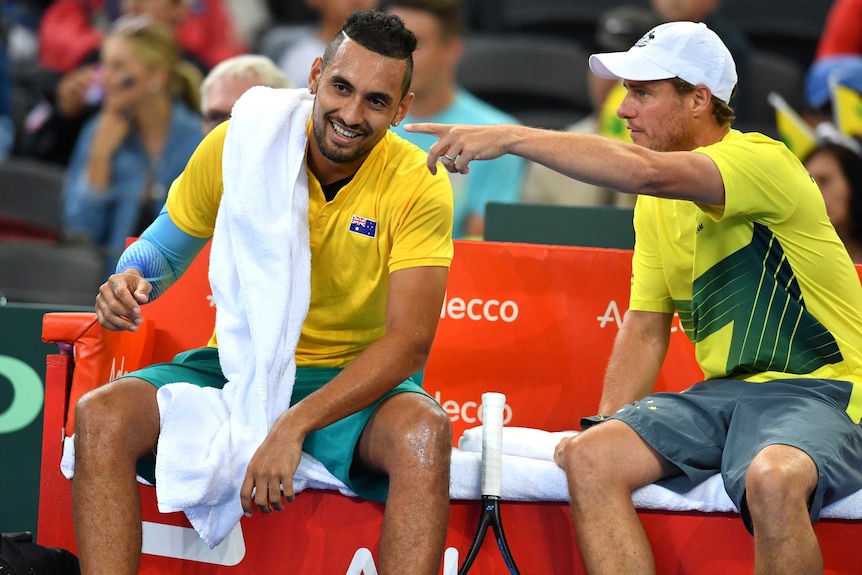 Nick Kyrgios has a laugh as he talks to Lleyton Hewitt at a change of ends during the Davis Cup tie in Brisbane.