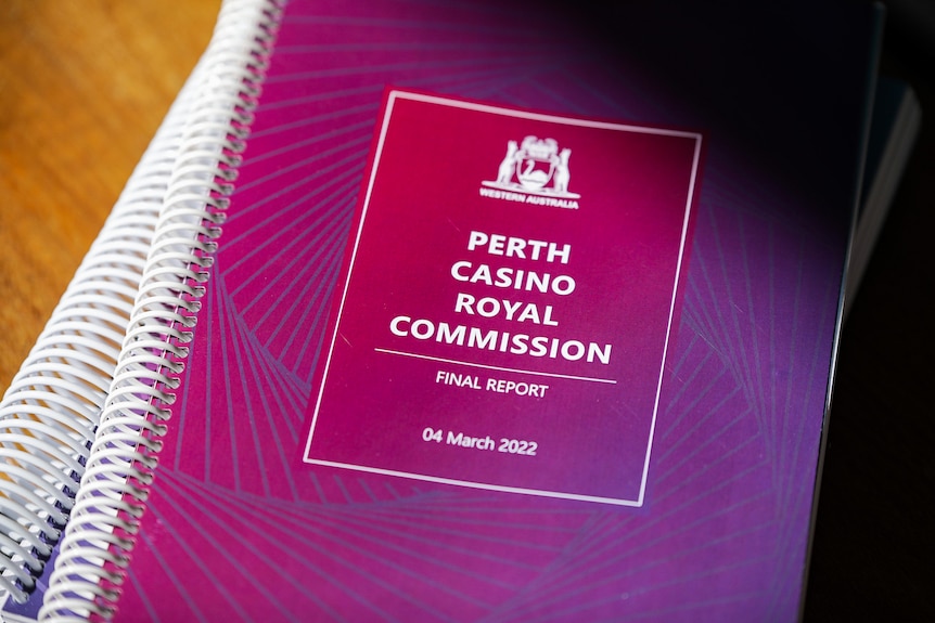 Two bound books with purple covers stacked on top of each other, with the words 'Perth Casino Royal Commission' on the front.