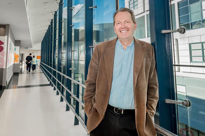 A man standing in a hospital smiling
