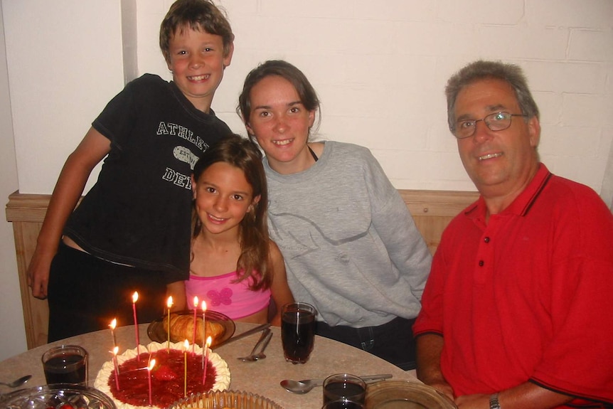 Old photograph of a younger Paul Rankin with kids, with birthday cake on table in front.