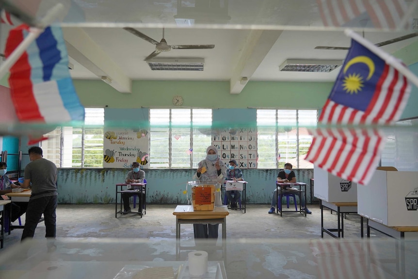 A woman castes a vote at a polling station during a state election on the outskirts of Kota Kinabalu, Malaysia.