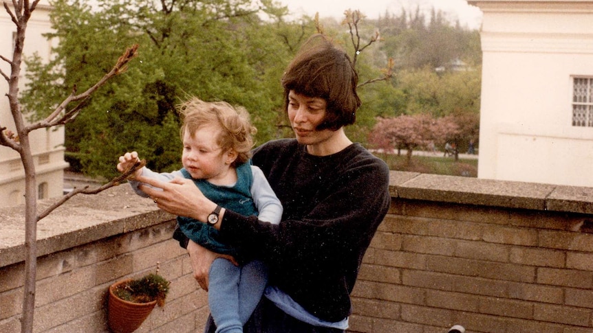 Scanned image of Olivia Humphreys as a baby, in her mother Cat's arms, reaching out to a tree.