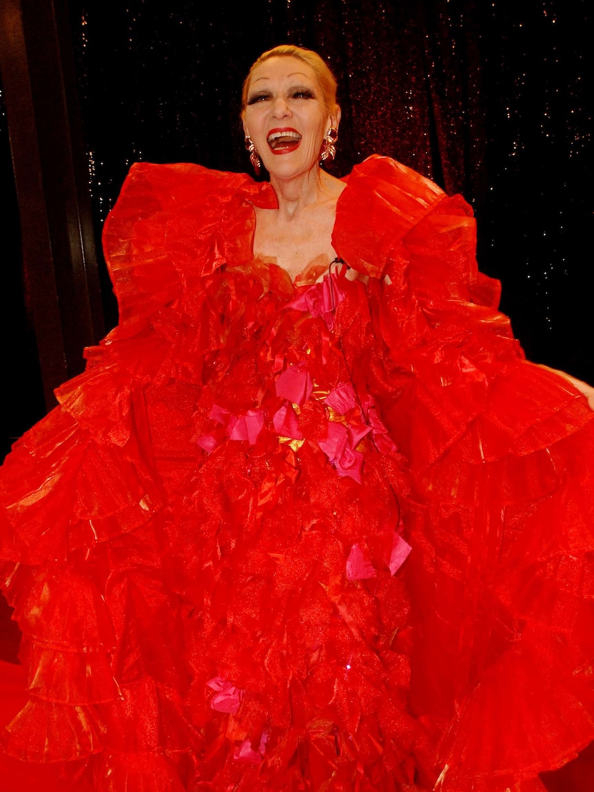 Jeanne Little on the red carpet wearing a frilled dress and floor-length wrap