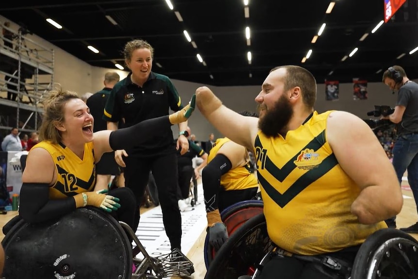 Australian wheelchair rugby players high-five after winning the world championship final against the United States.