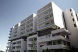 the exterior of a white apartment building