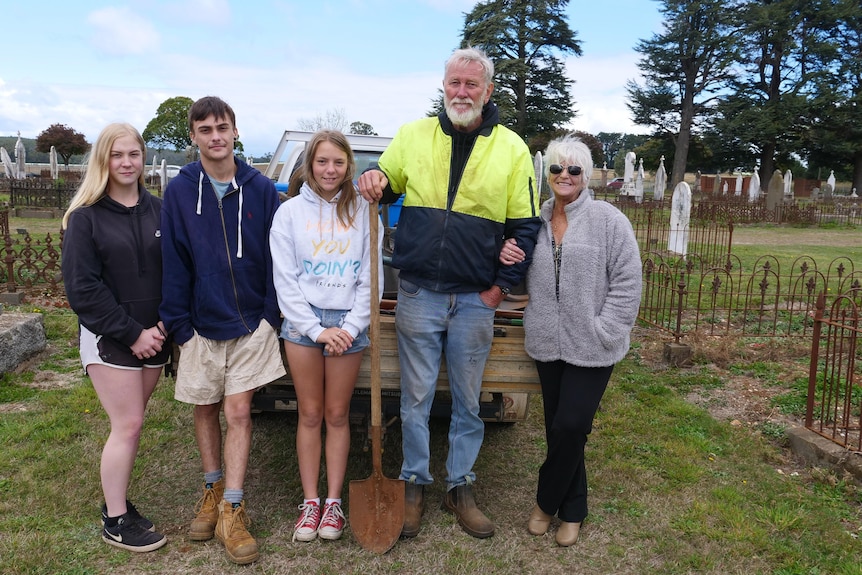 two seniors standing with three teenagers in a graveyard. 