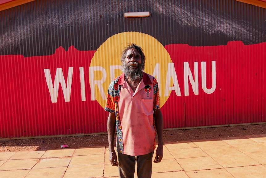 A profile of Balgo elder Daniel Rockman in front of the Aboriginal flag.