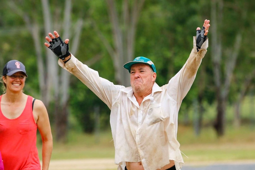 Dave Holleran raises his arms in triump as he crosses the finish line