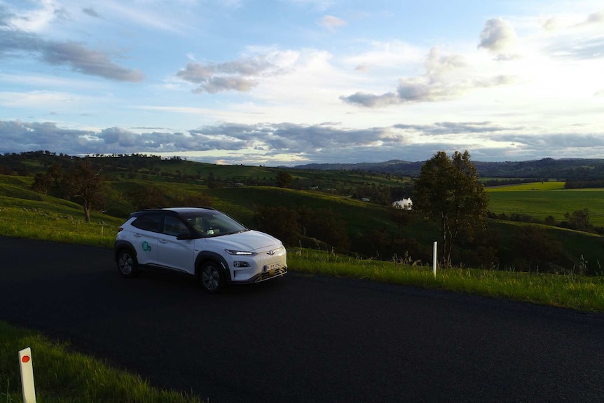 Car on a country road with a sunset in background