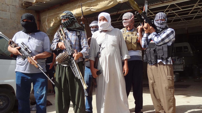 Iraqi Turkmen pose with their weapons as they ready to fight against militants led by ISIS