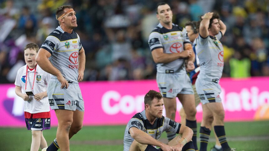 Dejected Cowboys players look on after grand final loss