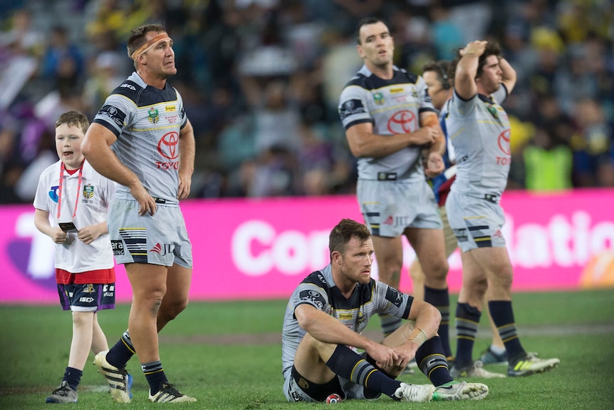 Dejected Cowboys players look on after grand final loss