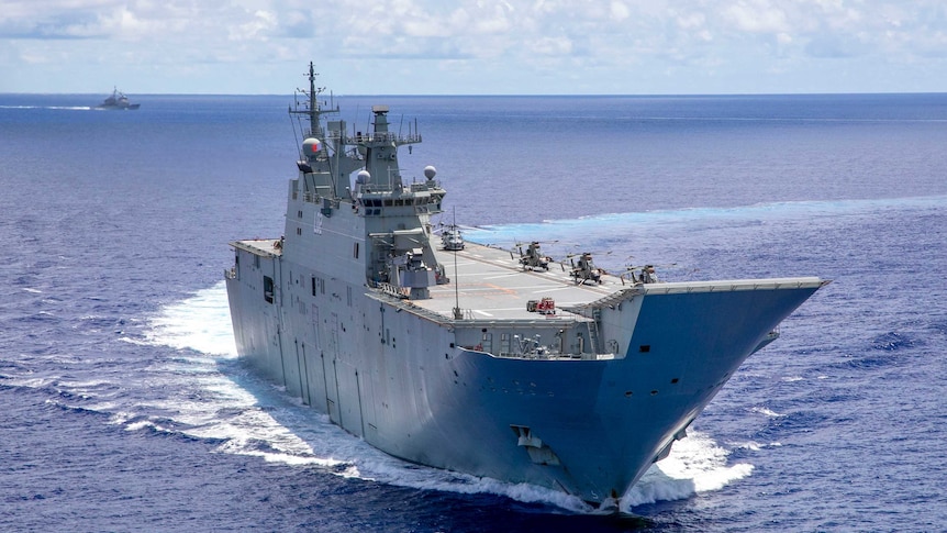 An Australian warship in the middle of the ocean with another warship in the distance background.